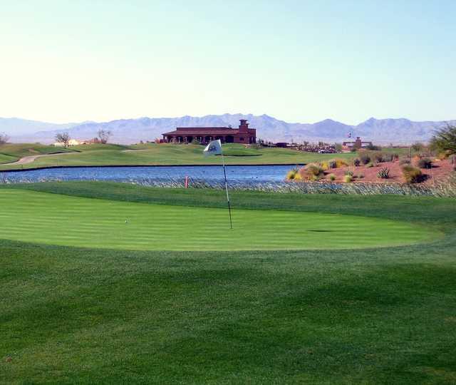 View of a green with the clubhouse in the background at El Rio Golf Club