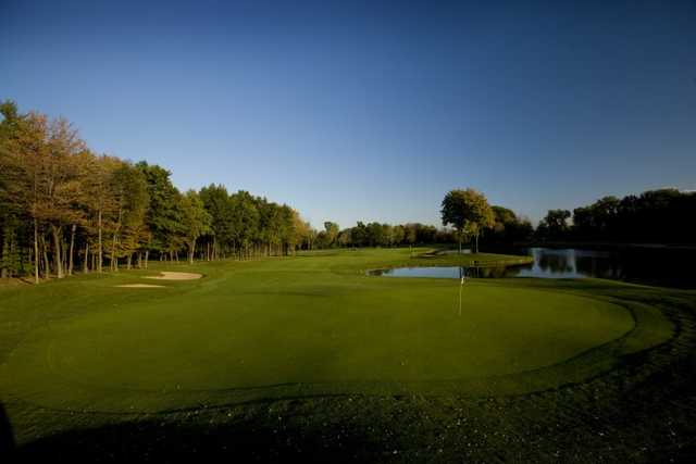 View of the 18th green surrounded by water at Cherry Creek Golf Club