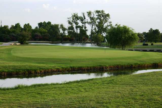 A view of a green surrounded by water at Willow Springs Country Club