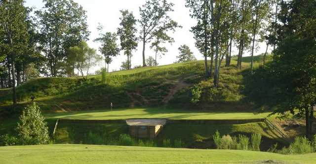 A view of the 12th green surrounded by water at Country Land Golf Course