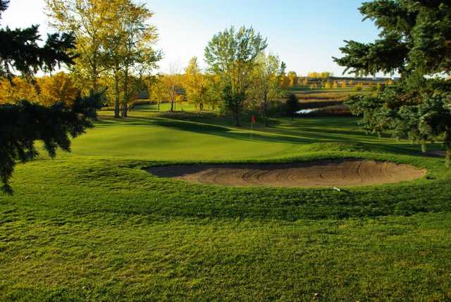 A view of a green protected by a bunker at Weyburn Golf Club