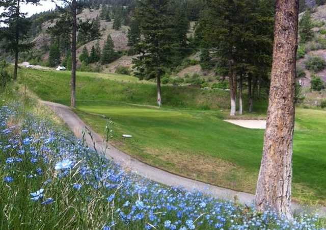 A view of a green protected by a bunker at Twin Lakes Golf Course