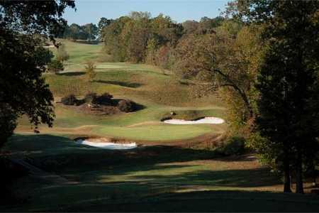 A view of a green protected by bunkers at Chimney Oaks Golf Club