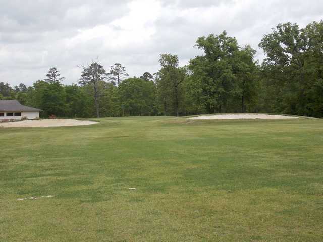 A view of a green flanked by bunkers at Neches Pines Golf Course