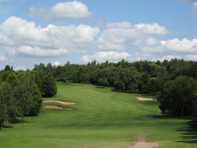 A view of the tree lined 10th green accompanied by several bunkers ant Bromsgrove Golf Course