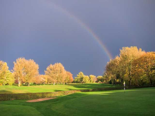 Beautiful shot of the 18th hole with a rainbow going over the course at  Heaton Moor Golf Club