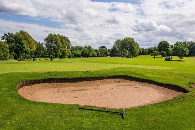A view of a hole protected by a bunker at Colin Park Leisure Golf Course