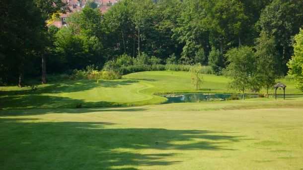 The sloping 17th green over waterat Bush Hill Park