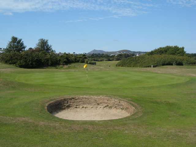 A view of the 11th green and surrounding mountains at Abersoch GC