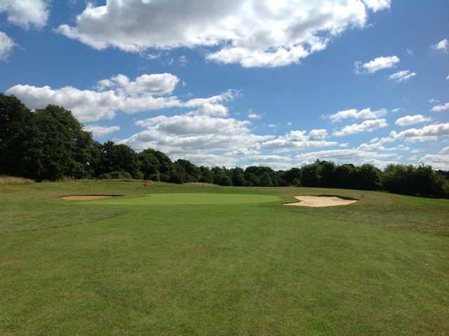 A view of teh 8th green and blue sky at Hurtmore Golf Club