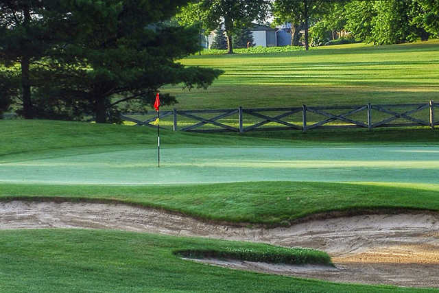 A view of a green protected by a bunker at Carlisle Golf and Country Club