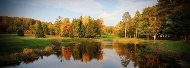Fall view of a green over a pond at Pine Hills Golf Course