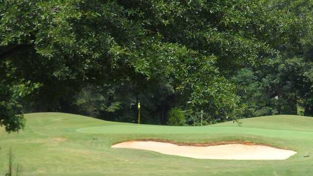 A view of a green protected by bunker at Willow Creek Golf Course