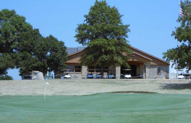 View of a green and clubhouse at Arkansas City Country Club