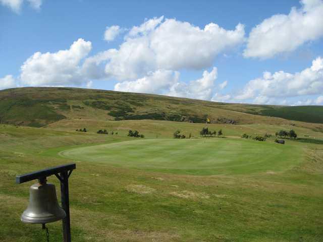 A View of the 14th green on a hilly backdrop at Church Stretton Golf Club 