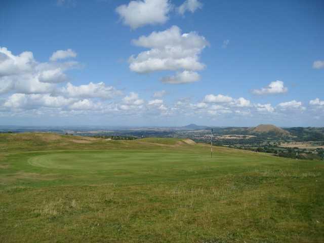 A picturesque view of the 9th green and hilly backdrop at Church Stretton Golf Club 