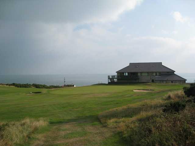 A view of the clubhouse overlooking the 18th green and the sea at Bull Bay Golf Club