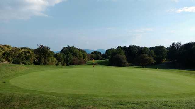 A view of the 3rd green and picturesque mountain backdrop at Llanymynech Golf Club