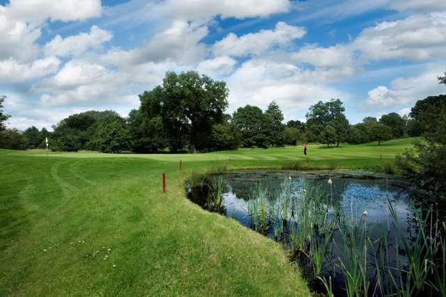 View across the pond of the 15th green at Tytherginton Golf Club