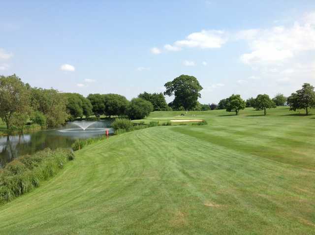 Scenic view of the 18th green and neighbouring pond at The Welcombe Golf Club