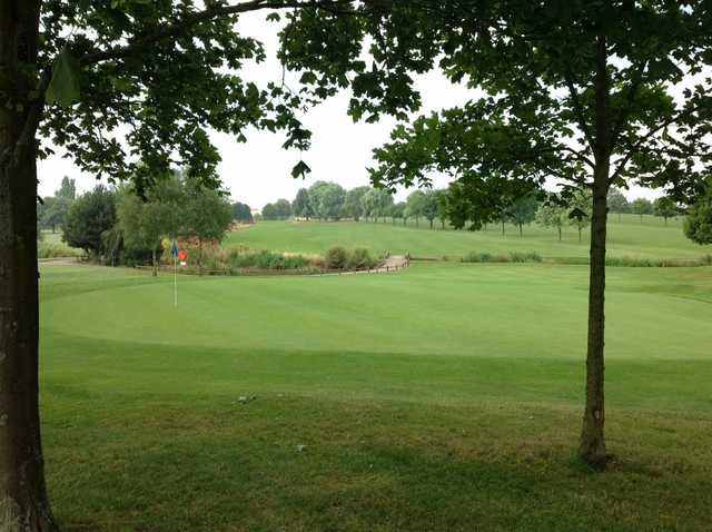 A view of the 10th green and surrounding trees at Windmill Village Golf Club