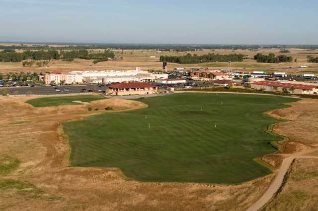 A view of the driving range at The Links at Rolling Hills with clubhouse in background