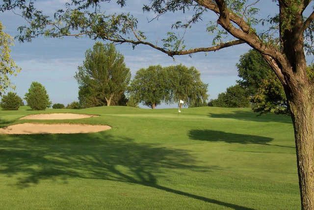 A sunny day view of a hole at Sugar Maple Golf Club
