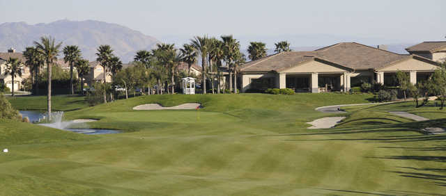 A view of a green  with the clubhouse in background at Sierra Lakes Golf Club.