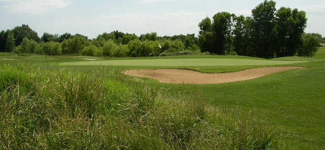 A view of a green protected by a bunker at Quail Ridge Golf Course