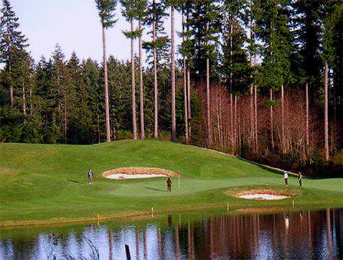 A view of a green surrounded by bunkers and water coming into play at Cascade from Gold Mountain Golf Course