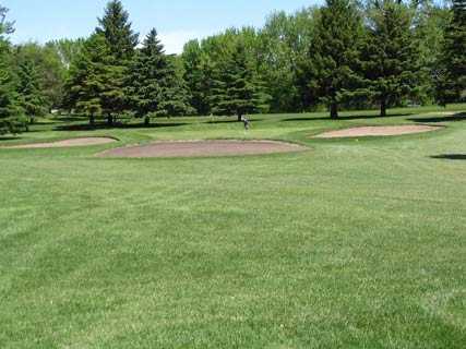 A view of the 2nd green protected by bunkers at Cokato Town & Country Club