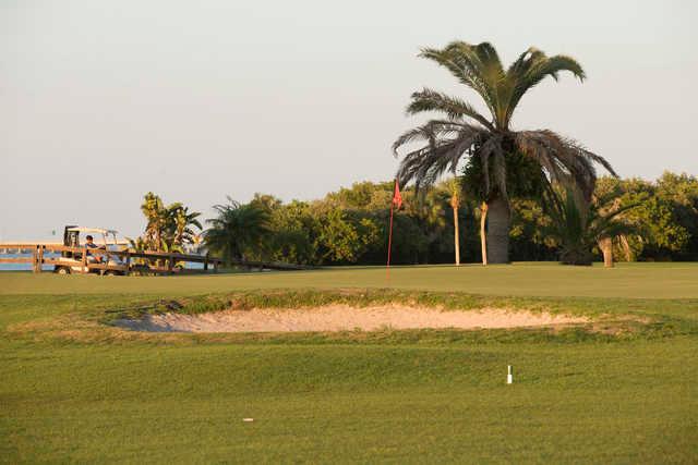 View of a green and bunker at Cove Cay Golf Club