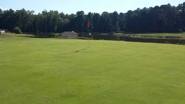 A view of a hole with water in the distance at Scotfield Country Club