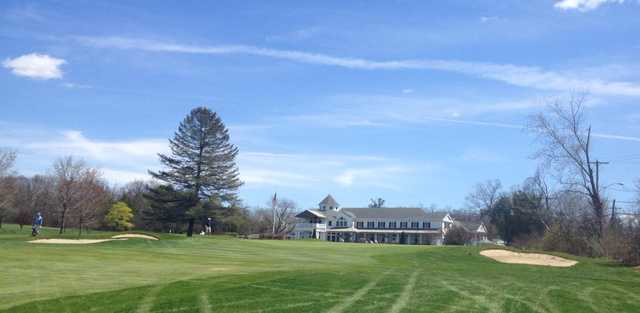 A spring day view of a fairway and the clubhouse at Edison Club