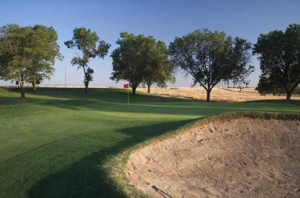 A view of a green with a huge bunker on the right at Mather Golf Course.