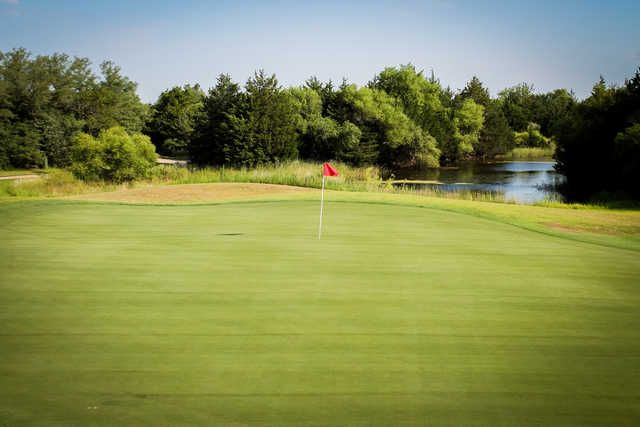 A view of the 1st green with water in the distance at Cottonwood Hills Golf Club