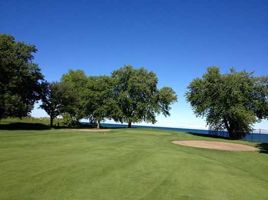 A view of a green guarded by bunkers at South Shore Golf Club