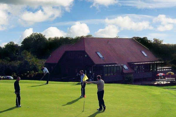 View of a green and clubhouse at Hadden Hill Golf Club