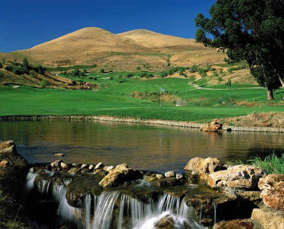 A view of a green with water in foreground at Hiddenbrooke Golf Club