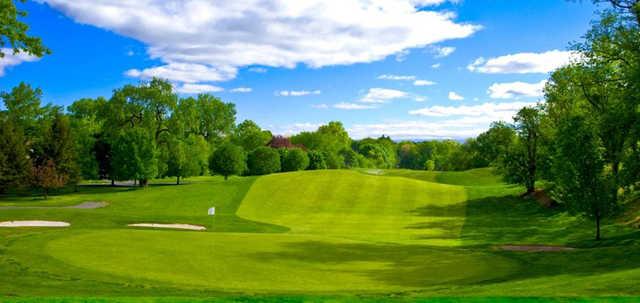 A sunny day view of a hole protected by bunkers at Galloping Hill Golf Course