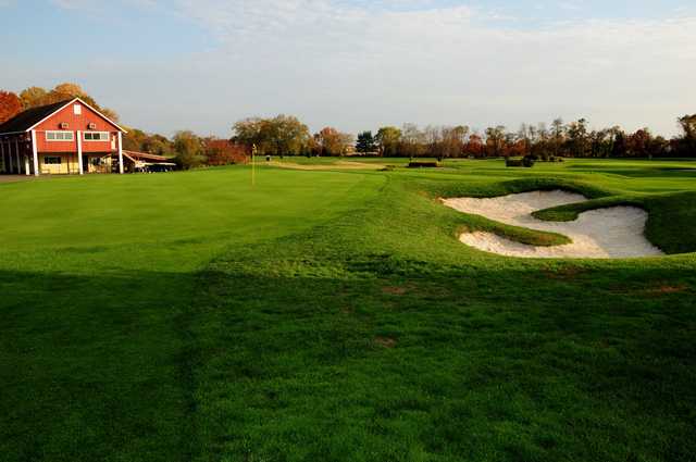 A view of a green protected by a tricky bunker at Golden Pheasant Golf Club