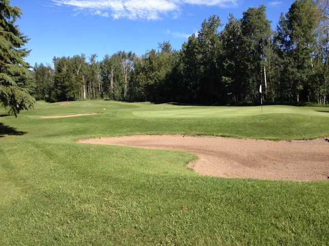A view of a hole protected by manicured sand traps at Whitecourt Golf and Country Club