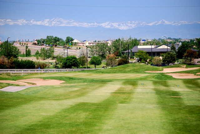 A view of green protected by bunkers with clubhouse in background at Thorncreek Golf Club
