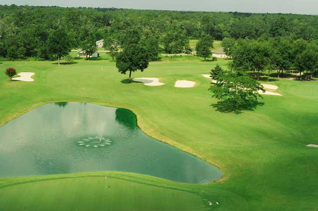 A view of a green with water in background at Wildwood Country Club