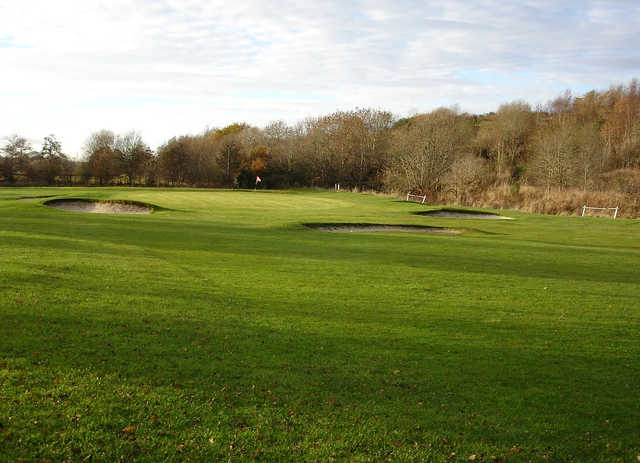 A view of a green surrounded by a collection of bunkers at Bridgend Golf Club