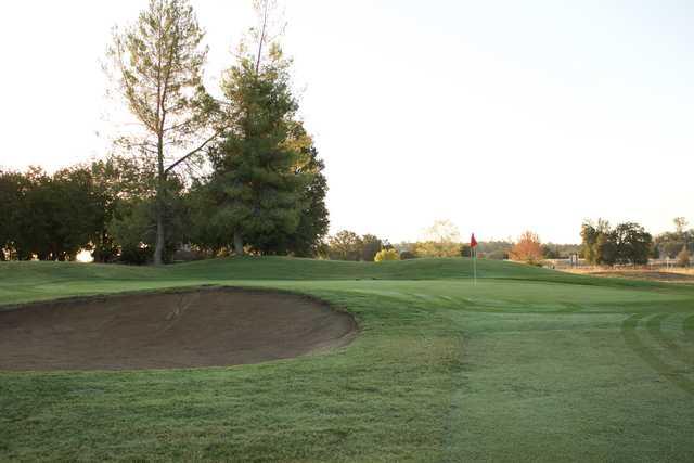 A view of a green guarded by a bunker at Grape Ranch Golf Club.