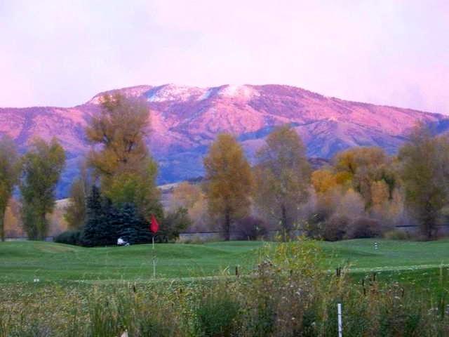 A view of a green with mountains in the distance at Steamboat Golf Club.