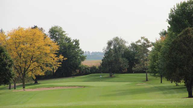 A view of a hole guarded by bunkers and a fall golden tree at Monroe Country Club.