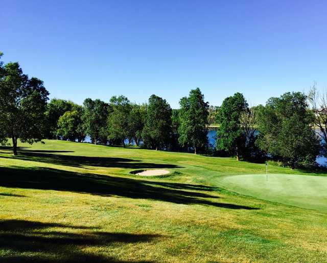 A sunny day view of a green at The River Golf Course.