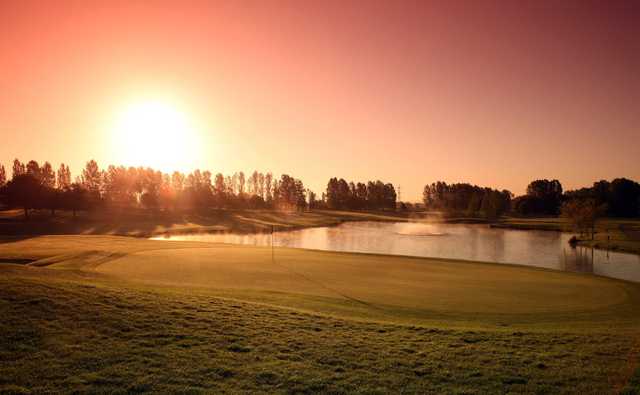 A sunset view of a green with water coming into play at Belfry Golf Club.